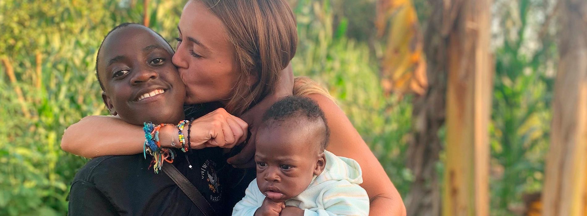 Fundadora de Babies Uganda besando a dos niños